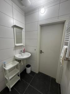 a white bathroom with a sink and a mirror at Gästehaus OG in Cologne