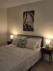 a bedroom with a bed with two lamps on tables at Casa Bali Tropical Escape in Vega Alta +21 photos