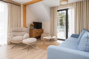 a living room with a blue couch and a chair at Sea You Jantar in Jantar