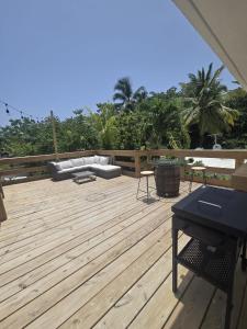 a large wooden deck with a couch and a piano at Casa Bali Tropical Escape in Vega Alta