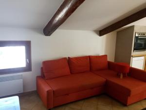 a living room with a red couch and a window at Le Pied-Redon in Lafare