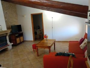 a living room with a red couch and a table at Le Pied-Redon in Lafare