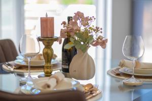 a table with a bottle of wine and a vase of flowers at Villa Green Bay in Vela Luka