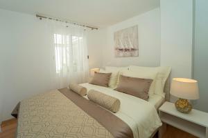 a white bedroom with a large bed with pillows at Villa Green Bay in Vela Luka +126 photos
