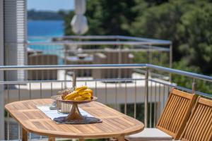a bowl of bananas on a table on a balcony at Villa Green Bay in Vela Luka