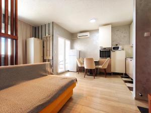 a bedroom with a bed and a kitchen with a table at Good Inn in Bar