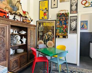 a dining room with a table and colorful chairs at BRIC à BRAC eclectic rooms in Uggiano la Chiesa