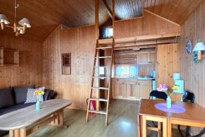 a living room with a wooden cabin with a ladder at Odin Camping AS in Svensrud
