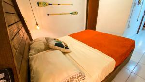 a small room with a bed in a room with aperature at Pipa Surf House in Pipa