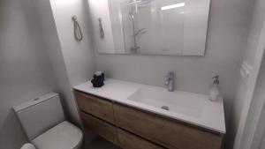 a bathroom with a sink and a toilet and a mirror at Sky in Noja +11 photos