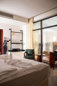 a bedroom with a bed and a chair and a window at Souq Beach Hotel فندق سوق الشاطئ in Salalah