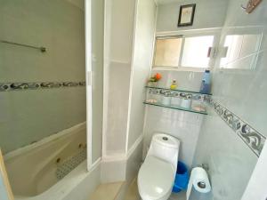 a white bathroom with a toilet and a bath tub at "Casitas Arcoiris" Excelente ubicación - Petfriendly in Isla Mujeres