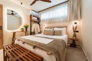 a bedroom with a large bed and a wooden bench at Ammosphere in Nea Peramos +54 photos