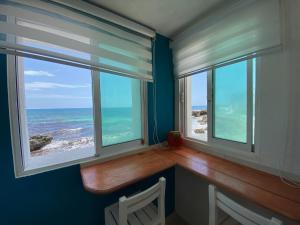 a room with two windows with the view of the ocean at "Casitas Arcoiris" Excelente ubicación - Petfriendly in Isla Mujeres