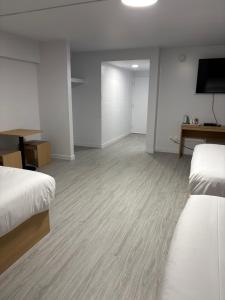 a hotel room with two beds and a flat screen tv at Rundle Inn and Suites in Edmonton