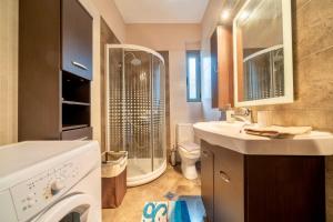 a bathroom with a washing machine and a sink at Villa Violetta in Nea Anchialos