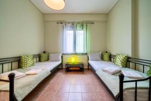 a room with two beds and a table at Villa Violetta in Nea Anchialos