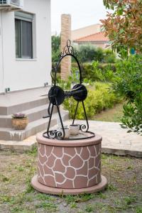 a statue of a bird bath in a yard at Villa Violetta in Nea Anchialos +24 photos