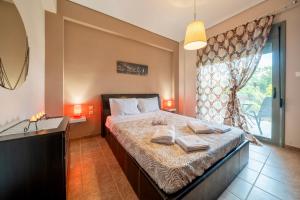 a bedroom with a bed with two towels on it at Villa Violetta in Nea Anchialos