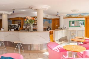 a restaurant with pink chairs and a bar at Hotel Tre Rose New 2026 in Riccione