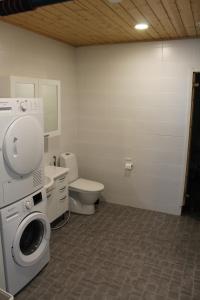 a bathroom with a washing machine and a toilet at Pikkurinki 27 As 2, Härmä in Härmä