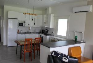 a kitchen with a table and chairs and a kitchen with white cabinets at Pikkurinki 27 As 2, Härmä in Härmä