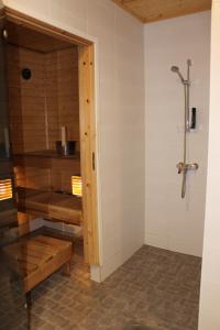 a bathroom with a shower and a bench in it at Pikkurinki 27 As 2, Härmä in Härmä