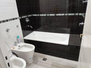a bathroom with a white toilet and a bath tub at Casa chalet cerca nodo y estadio in Santiago del Estero