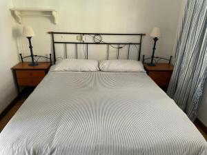 a bed in a bedroom with two tables and two lamps at La Vereda - Rural getaway, pool, golf & hiking lovers in Tacoronte
