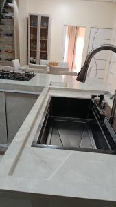 a kitchen with a sink in the middle at Suíte caripi in Barcarena