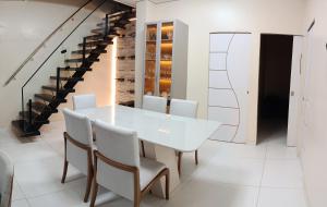 a white dining room with a white table and chairs at Suíte caripi in Barcarena