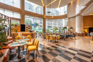 a restaurant with tables and chairs and windows at Holiday Inn Shanghai Nanjing Road by IHG in Shanghai
