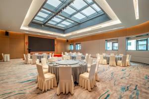 a conference room with tables and chairs and a large skylight at Holiday Inn Shanghai Nanjing Road by IHG in Shanghai