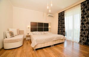 a bedroom with a bed and a chair and a window at La Hacienda in Ulcinj