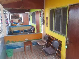 a room with chairs and a bar in a building at baobolong ghuesthouse in Lamin Koto