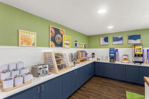 a kitchen with blue cabinets and green walls at Spark By Hilton Beckley in Beckley