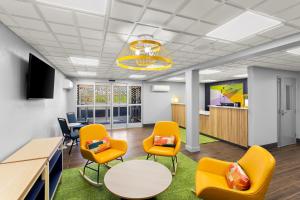 an office with orange chairs and a table andools at Spark By Hilton Beckley in Beckley