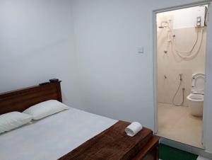 a bedroom with a bed and a shower and a toilet at Eco Bliss Ragama in Ragama