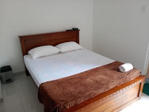 a bedroom with a bed with a wooden headboard at Eco Bliss Ragama in Ragama +8 photos