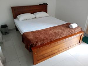 a bedroom with a bed with a wooden bed frame at Eco Bliss Ragama in Ragama