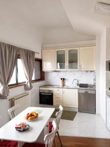 a kitchen with white cabinets and a white table and chairs at Sweets Suites Espinho in Espinho