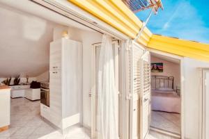 a kitchen with white walls and a yellow ceiling at Grandmother's Attic in Furore