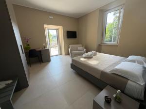 a bedroom with a bed and a chair and a window at Villa Casinelli B&B in Isola del Liri