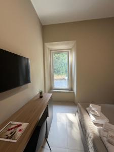 a room with a table and a tv and a window at Villa Casinelli B&B in Isola del Liri