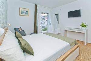 a bedroom with a large white bed and a window at Hvar Deluxe Rooms in Hvar