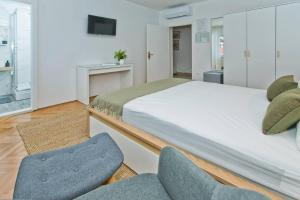 a bedroom with a large bed and two chairs at Hvar Deluxe Rooms in Hvar