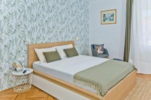 a small bedroom with a bed and a chair at Hvar Deluxe Rooms in Hvar