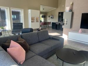 a living room with a couch and a table at Moderne enebolig med gratis parkering in Alta