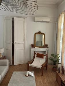 a living room with a couch and a mirror at L'Écrin in Béziers