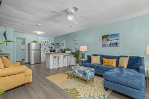 a living room with a blue couch and a kitchen at Latitude 26 Waterfront Boutique Resort - Fort Myers Beach in Fort Myers Beach